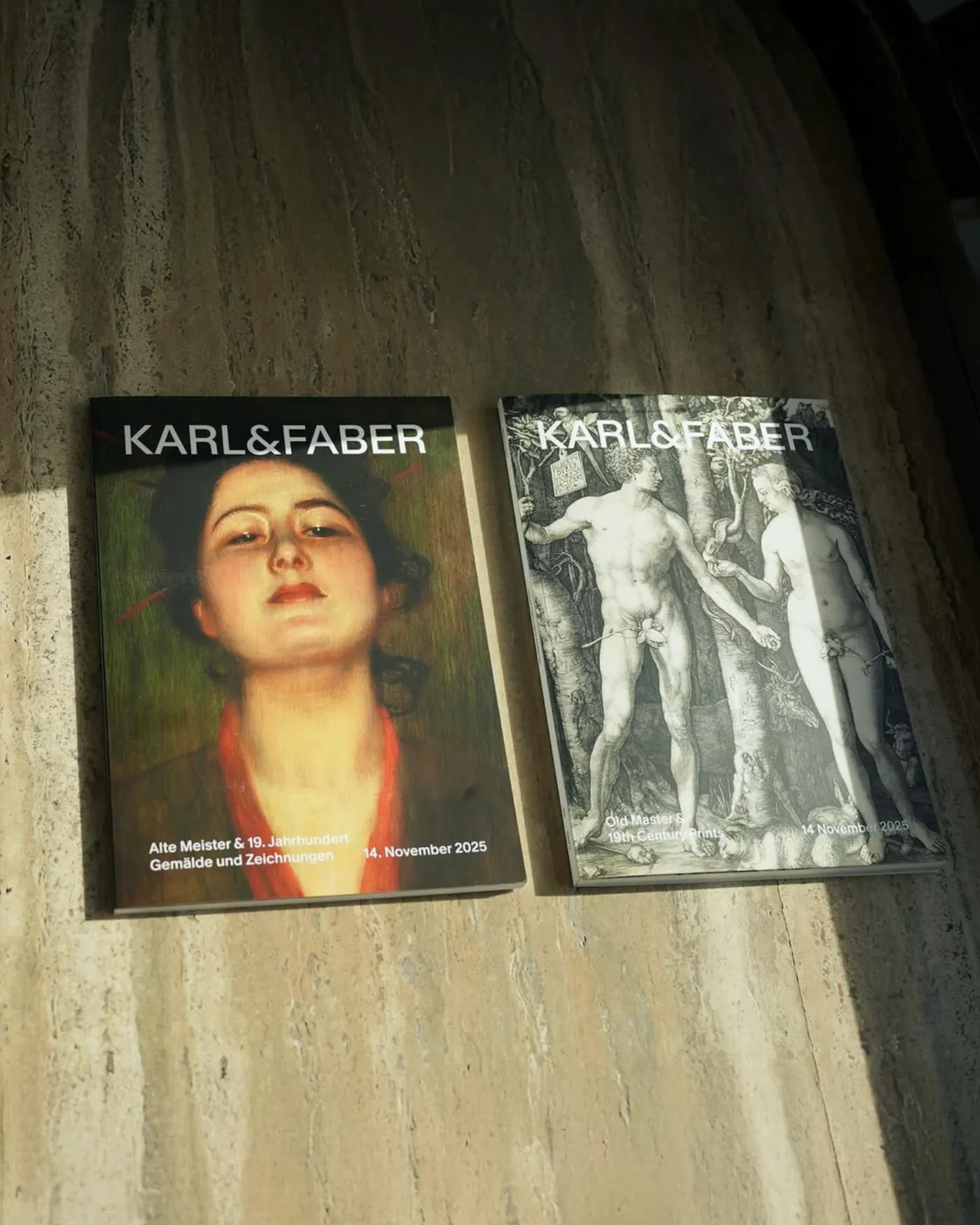 Two Karl & Faber auction catalogs resting on a stone ledge